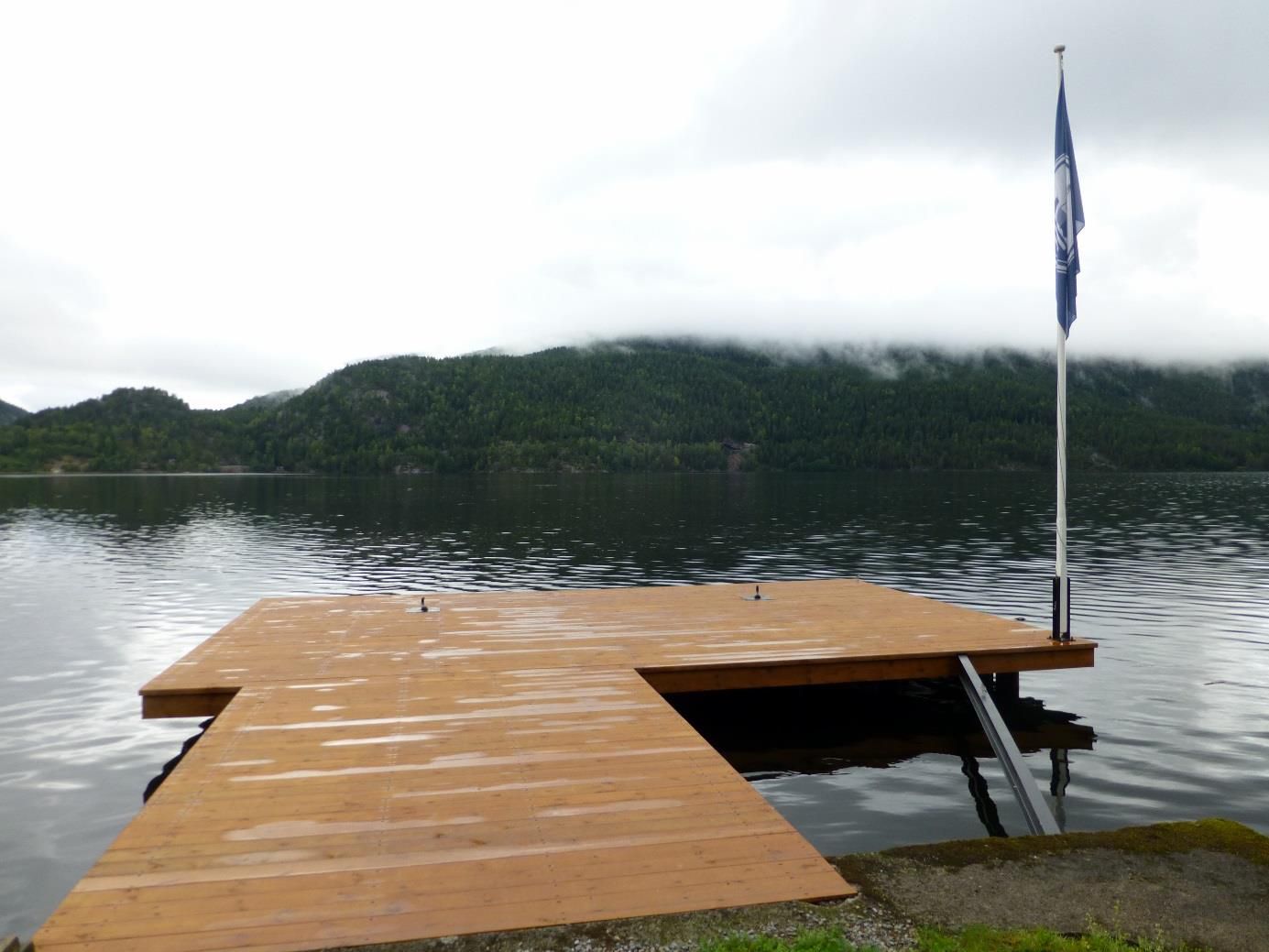 Brygga ferdig og overflatebehandla. Flaggstang og kanalflagg er tilbake på plass! Bildet tatt i fjor høst under flom. I 1927 sto vannet midt opp på pakkbuveggen, ca 2 meter over vannstanden vi har her.