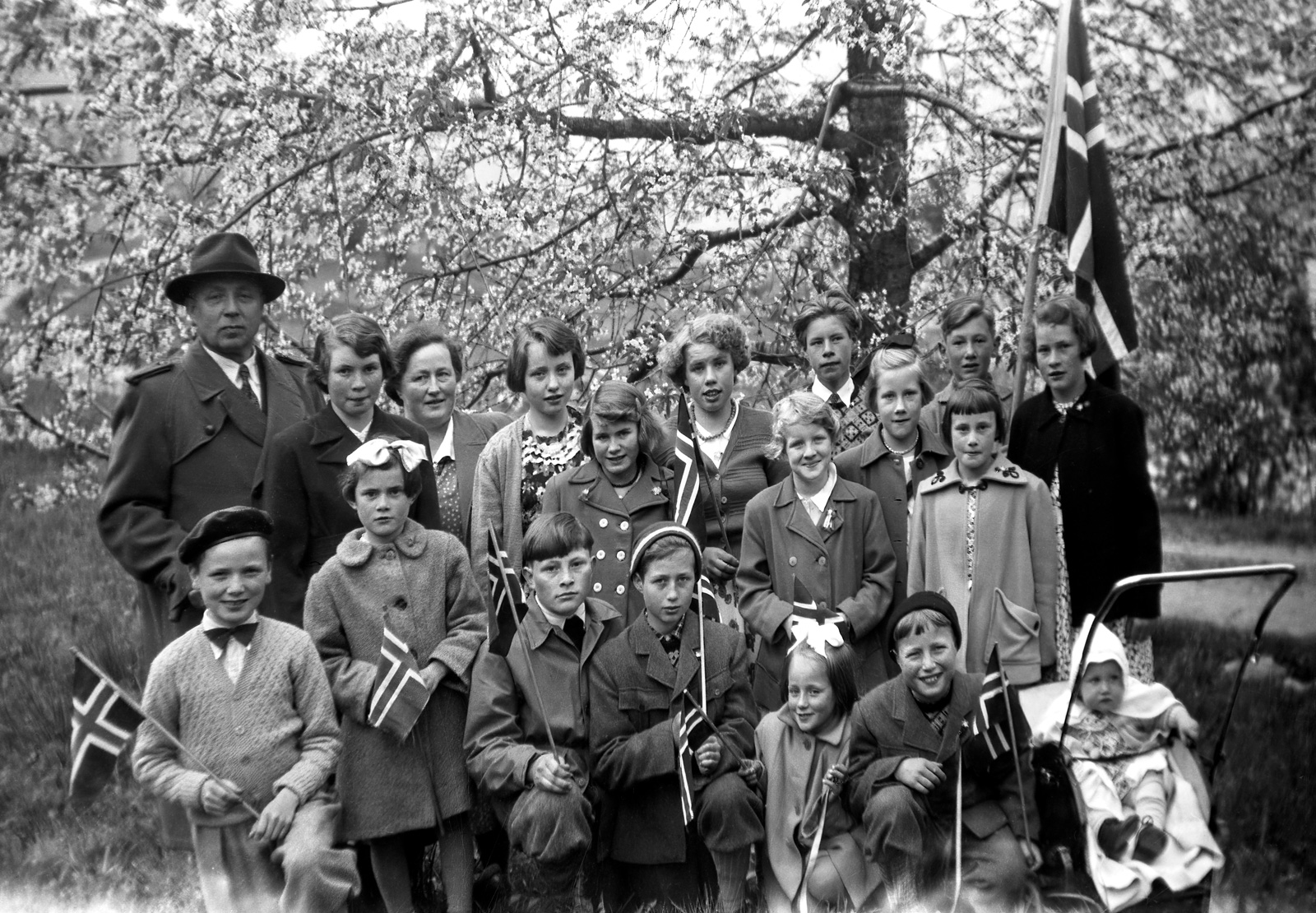 17. mai i Bergsto, året er 1953. Framme fv.: Sigmund Stemme,
Reidun Øigarden, Tarald Øigarden, Harald Lyshol, Astrid Lyshol,
Jostein Lyshol og i vogna Tordis Stemme. I midten: Bjørg Torsdalen,
Aslaug Strandkås, Anne Øigarden. Bak f.v.: Martinus Lyshol, Aud
Teigen, Åsta Lyshol, Anna Lisa Stemme, Mari Midtbøen, Torleif
Midtbøen, Solveig Teigen. Birger Berge, Gunvor Øigarden.